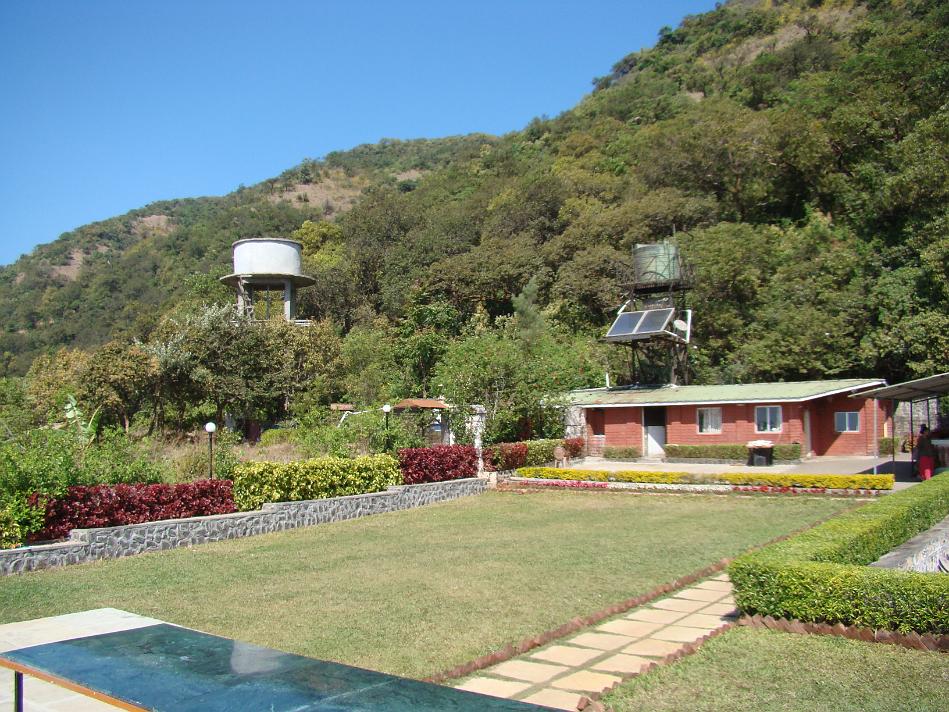 DSC02008.JPG - Puja Farm - Lawn. See lush green background. Also notice solar panel. There is boiler too. All rooms have Tata Sky Basic Plan connection