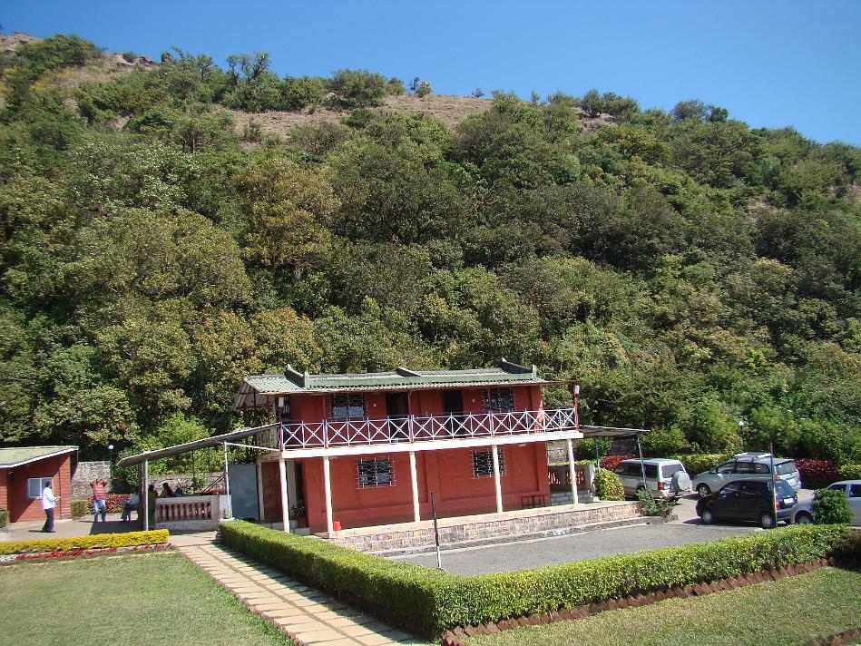 DSC02011.JPG - Puja Farmhouse with hill on the background. In front there is place to play volleyball/badmington etc. There is enough parking space available as well..