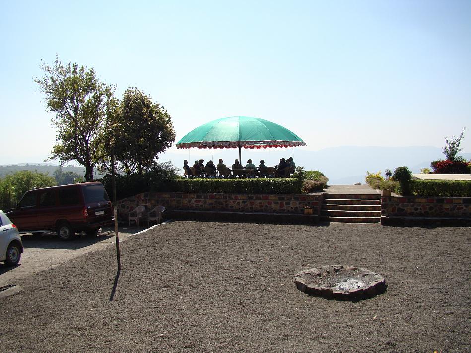 DSC02021.JPG - The big umbrella specially got made by Dilip More of Puja Farm. There is lot of breeze but umbrella withstands that. Plastic chairs topple.